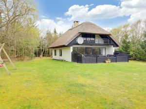 a small house with a thatched roof on a yard at Holiday Home Rigitte - 1-5km from the sea by Interhome in Pandrup