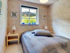 un dormitorio con una cama y una ventana en Holiday Home Tian - from the sea by Interhome, en Hadsund