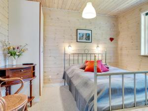 Un dormitorio con una cama y una pared de madera. en Holiday Home Tian - from the sea by Interhome, en Hadsund