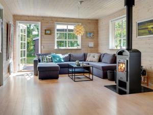 Una sala de estar con un sofá y una estufa de leña. en Holiday Home Tian - from the sea by Interhome, en Hadsund