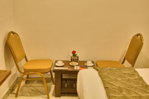 a room with a table and chairs and a bed at Arrival Inn Transit Hotel Bangalore Airport in Bangalore