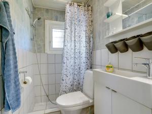 a bathroom with a toilet and a sink and a shower at Holiday Home Savina - from the sea by Interhome in Hadsund