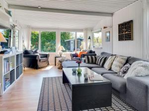 a living room with a couch and a table at Holiday Home Savina - from the sea by Interhome in Hadsund +13 photos