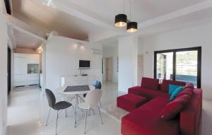 a living room with a red couch and a table and chairs at Villa Pucalo by Villas Guide in Kampor