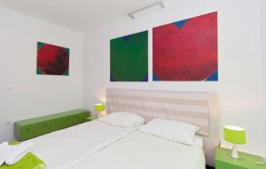 a bedroom with a bed and two paintings on the wall at Villa Pucalo by Villas Guide in Kampor +29 photos