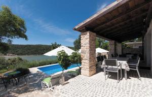 a patio with a table and chairs and a pool at Villa Pucalo by Villas Guide in Kampor