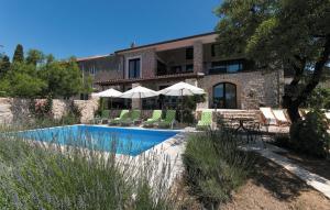 a house with a swimming pool with chairs and umbrellas at Villa Pucalo by Villas Guide in Kampor