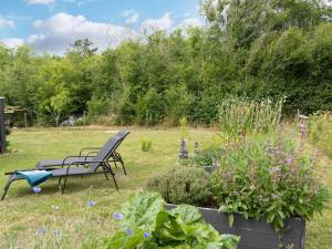a garden with two chairs and some plants at Holiday Home Thersten - 500m to the fjord by Interhome in Løgsted