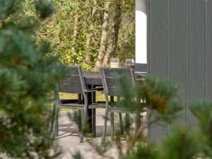 two chairs sitting around a table on a porch at Holiday Home Grimi - 4km from the sea by Interhome in Fjerritslev