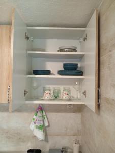 a kitchen cabinet with plates and dishes on it at Apartman Lena in Dobrota