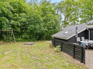 a backyard with a fence and a house at Holiday Home Magh by Interhome in Års