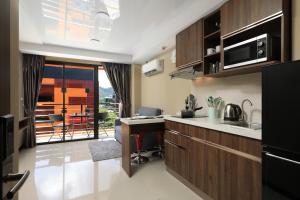 a kitchen with a counter and a dining room at 1bdr apartment NaiHarn Beach condo by Capital Pro in Phuket Town