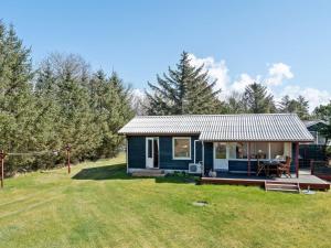 a blue tiny house with a porch and a yard at Holiday Home Josefiina - 450m to the inlet by Interhome in Løgsted