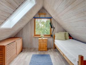 a small bedroom with a bed and a window at Holiday Home Valo - 400m to the fjord by Interhome in Løgsted