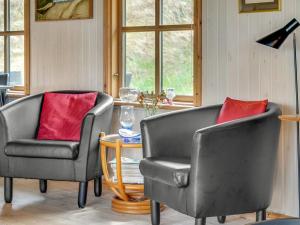 two chairs with red pillows in a living room at Holiday Home Marite - 200m from the sea by Interhome in Pandrup +18 photos