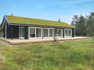 a small black house with a grass roof at Holiday Home Melinda - 2km from the sea by Interhome in Pandrup