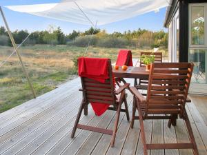 a table and two chairs on a deck with a view at Holiday Home Melinda - 2km from the sea by Interhome in Pandrup