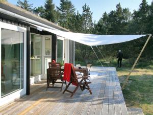 a patio with a table and chairs under a tent at Holiday Home Melinda - 2km from the sea by Interhome in Pandrup +21 photos