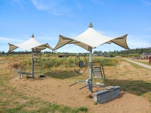 two play structures with umbrellas in a field at Holiday Home Dorithea - 3-5km from the sea by Interhome in Brovst +23 photos