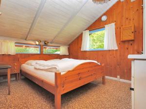 a bedroom with a large bed in a wooden room at Holiday Home Annegrete - 4km from the sea by Interhome in Fjerritslev