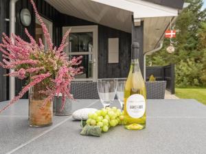 a bottle of wine and a bunch of grapes on a table at Holiday Home Frida - 700m from the sea by Interhome in Fjerritslev +17 photos