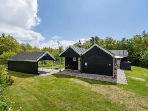 a black house with a pitched roof at Holiday Home Eireen - 600m to the fjord by Interhome in Farsø