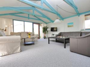 a living room with blue ceilings and a couch and tables at Holiday Home Momme - 500m from the sea by Interhome in Fjerritslev