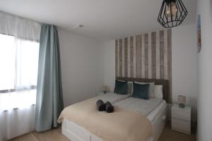 a bedroom with a bed with two shoes on it at OceanEye Apartment with heated pool in Mogán +30 photos