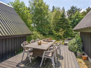 a wooden table and chairs on a wooden deck at Holiday Home Jütte - 2km to the fjord by Interhome in Farsø