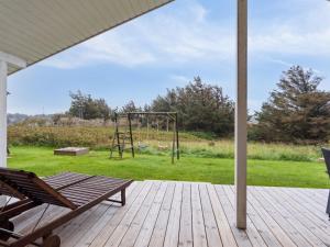 un portico con una panchina e un parco giochi di Holiday Home Herbiorn - 403m from the sea by Interhome a Hjørring