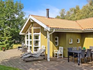 a house with a deck with a table and chairs at Holiday Home Karitte - 5km from the sea by Interhome in Fjerritslev