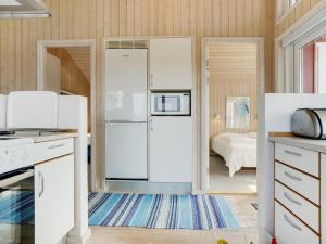 1 dormitorio y cocina con nevera blanca. en Holiday Home Iacobus - 400m from the sea by Interhome, en Hjørring 24 fotos más