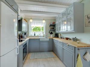a kitchen with blue cabinets and a window at Holiday Home Tamer - 500m to the fjord by Interhome in Farsø +21 photos