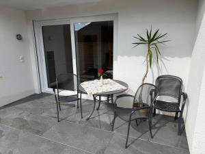 a table and chairs on a patio with a plant at Ferienwohnung Waldrose in Oberharmersbach