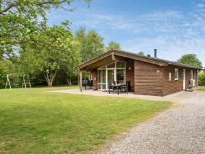 a small wooden cabin with a picnic table in a field at Holiday Home Els - 900m from the sea by Interhome in Fjerritslev