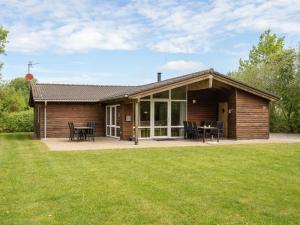 a small wooden house with a patio and grass at Holiday Home Els - 900m from the sea by Interhome in Fjerritslev