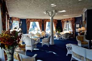 a room with chairs and tables and windows at Stafford's Bay View Inn in Petoskey