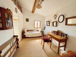un salon avec une table et un lit dans l'établissement La Maison près de la Fontaine, à Salles-sous-Bois