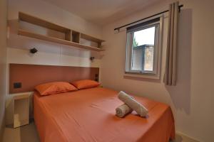 een slaapkamer met een bed met oranje lakens en een raam bij Vertacoflav in Carry-le-Rouet +11 foto's