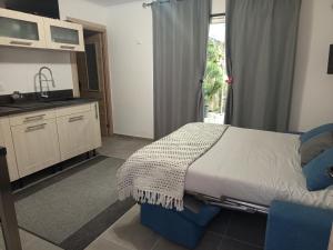 1 dormitorio con 1 cama y cocina con ventana en Fully equipped studio, en Saint-Germain-de-Joux