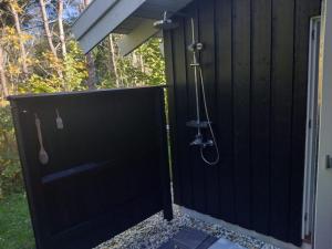 a shower in a black fence with a door at Holiday Home Harriet - 800m from the sea by Interhome in Hjørring