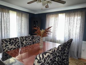 a living room with a table and a couch and windows at Casa Larisa Borsa in Borsa