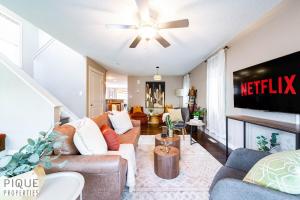 a living room with a couch and a tv at Chic 6BDRM Getaway - KingBed - Patio - BBQ - Garage - Wifi in Edmonton