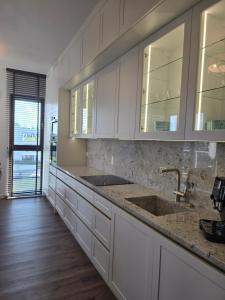 Una cocina con gabinetes blancos y un fregadero. en Sol Marina Apartament Marina Blue, en Wiślinka