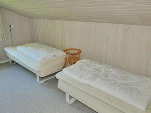 una stanza con due letti e una sedia di Holiday Home Otta - 779m from the sea by Interhome a Hjørring