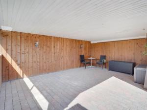 una camera con una parete in legno, tavolo e sedie di Holiday Home Bitta - 500m from the sea by Interhome a Fjerritslev