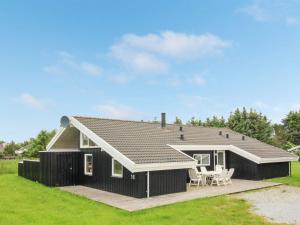 a black and white house with a patio at Holiday Home Franka - 950m from the sea by Interhome in Hjørring
