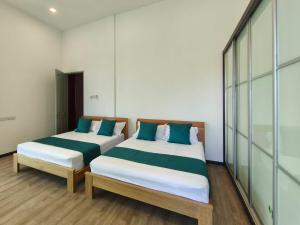 two beds in a room with glass walls at Sibu T3 Homestay- 5 Bedrooms in Sibu +10 photos