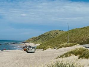 ein Boot an einem Sandstrand am Meer in der Unterkunft Holiday Home Vilmar - 1-2km from the sea by Interhome in Hjørring