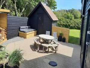 un patio con mesa de picnic y banco en Holiday Home Alfuin - 500m from the sea by Interhome, en Hjørring
